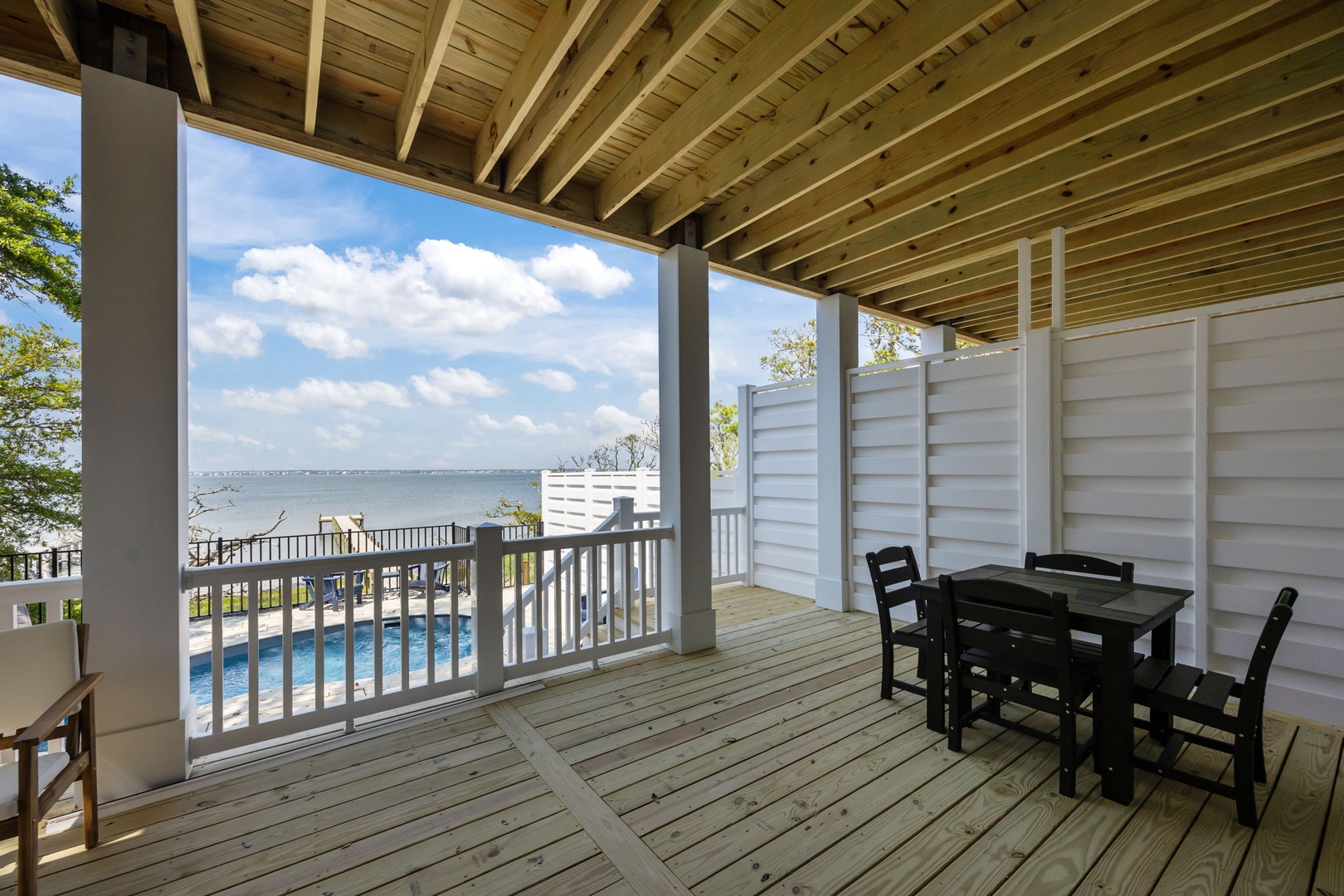 Your covered terrace offers stunning water views and poolside dining - perfect for morning coffee or sunset meals overlooking the serene waterfront.