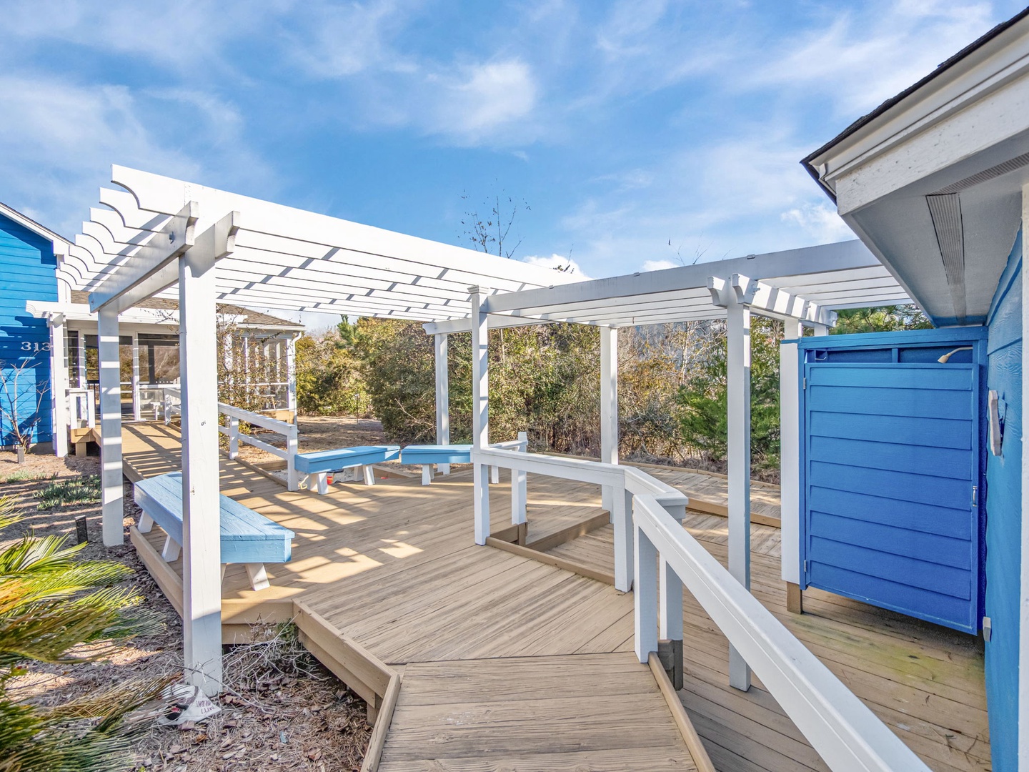 Relax on your private deck with pergola shade and outdoor dining space, surrounded by coastal charm.