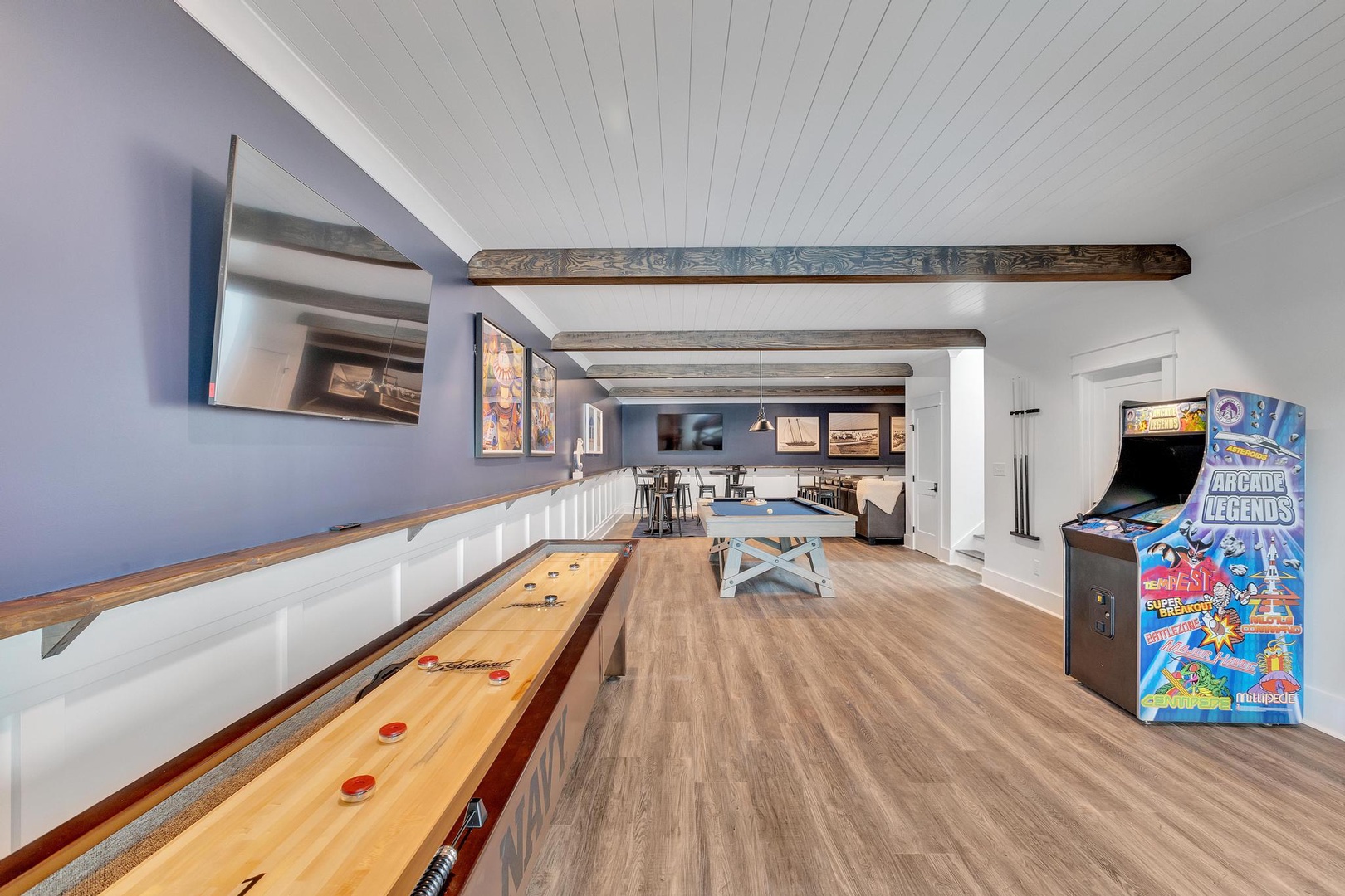 Your perfect retreat awaits, featuring a game room with shuffleboard, arcade, and cozy seating—complete with rustic beams and endless entertainment for your group.