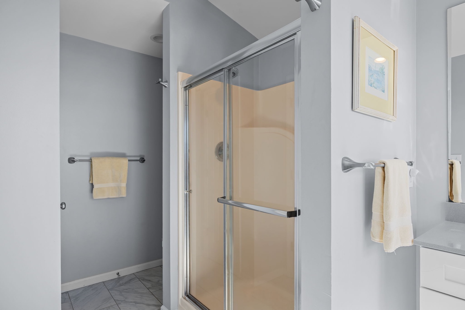 Step into your private sanctuary with a spacious glass-enclosed shower, fluffy towels, and soothing neutral tones for your perfect morning routine.