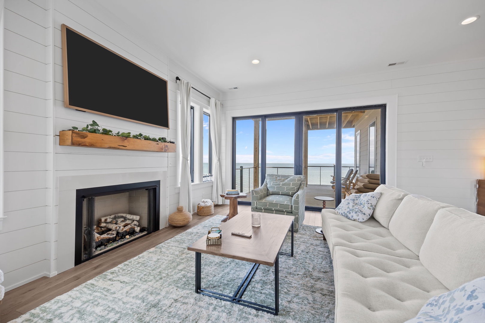 Cozy up by your fireplace while enjoying stunning views through floor-to-ceiling windows that flood this stylish living space with natural light.