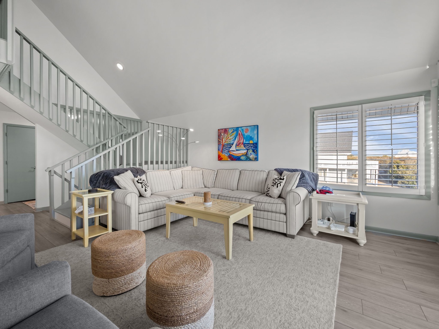 Unwind in your spacious living room with comfortable sectional seating and vibrant coastal artwork that sets the perfect vacation mood.