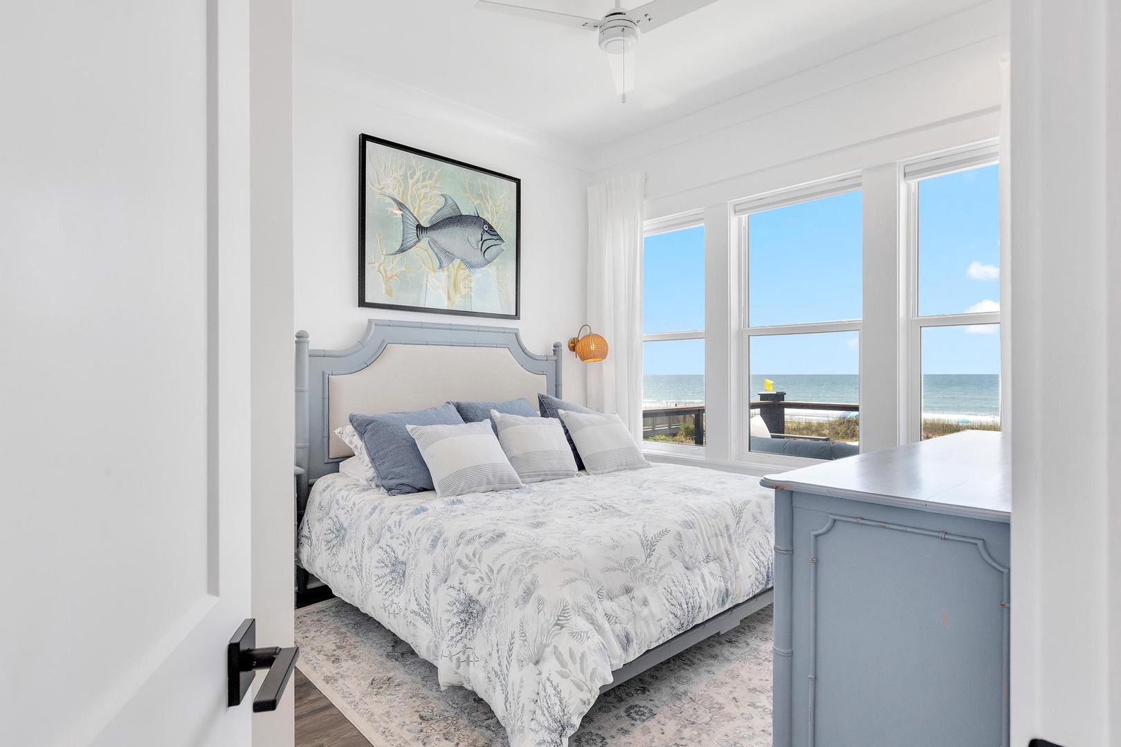 Wake up to stunning sea views framed by floor-to-ceiling windows, where the ocean and sandy beach become your morning vista in this serene coastal bedroom.