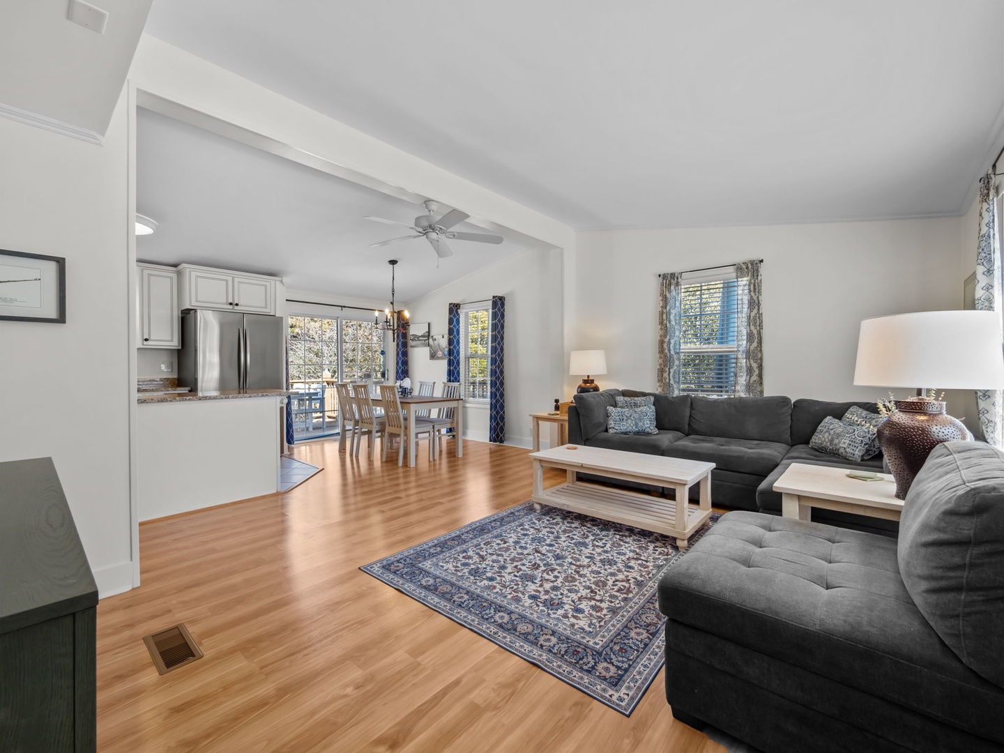 Relax in your spacious open-plan living area, where gleaming hardwood floors and comfortable sectional seating create the perfect spot for unwinding together.