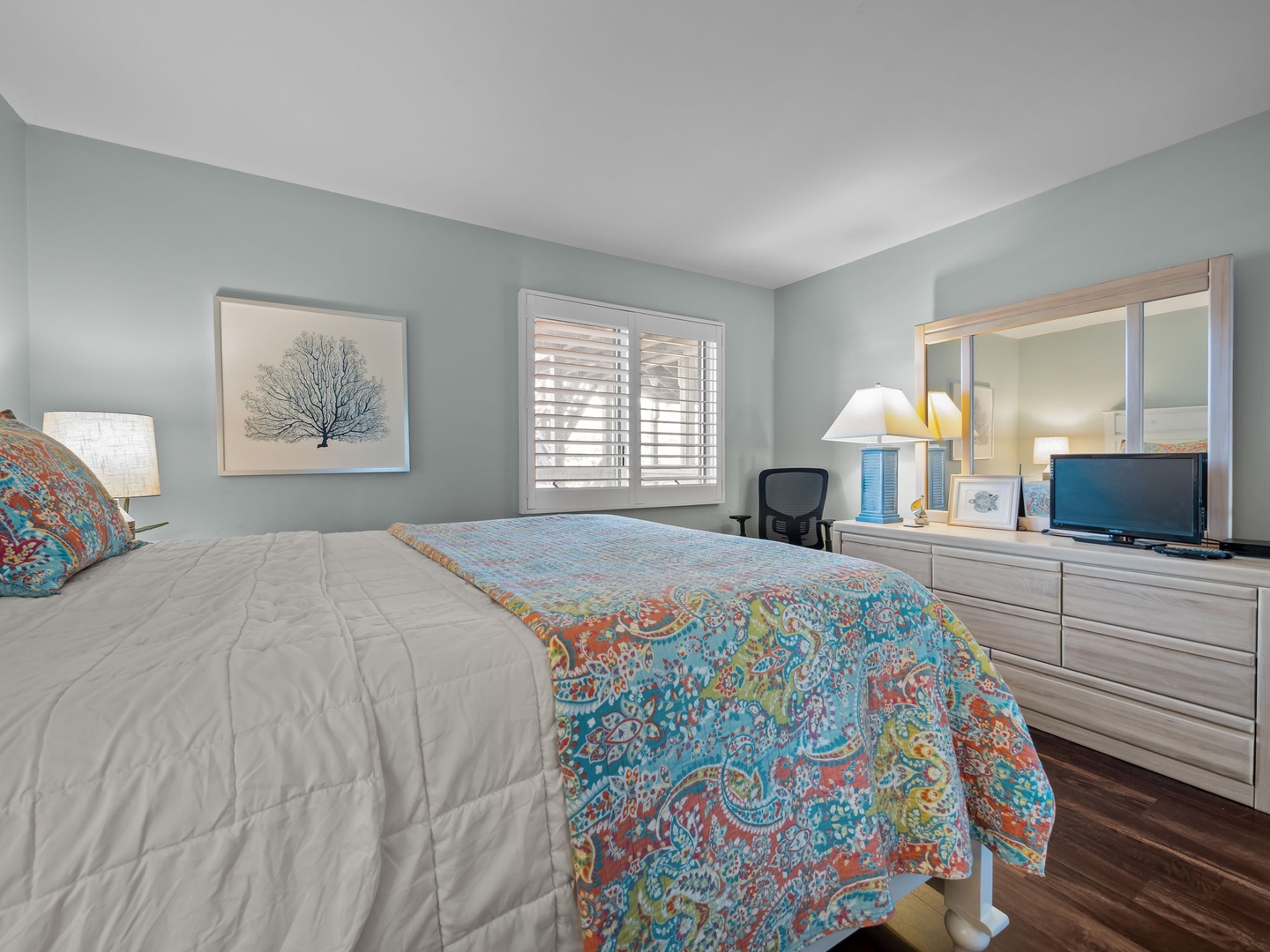 Rest peacefully in your coastal-inspired bedroom, where soft blue walls and vibrant linens create the perfect sanctuary for rejuvenating sleep.