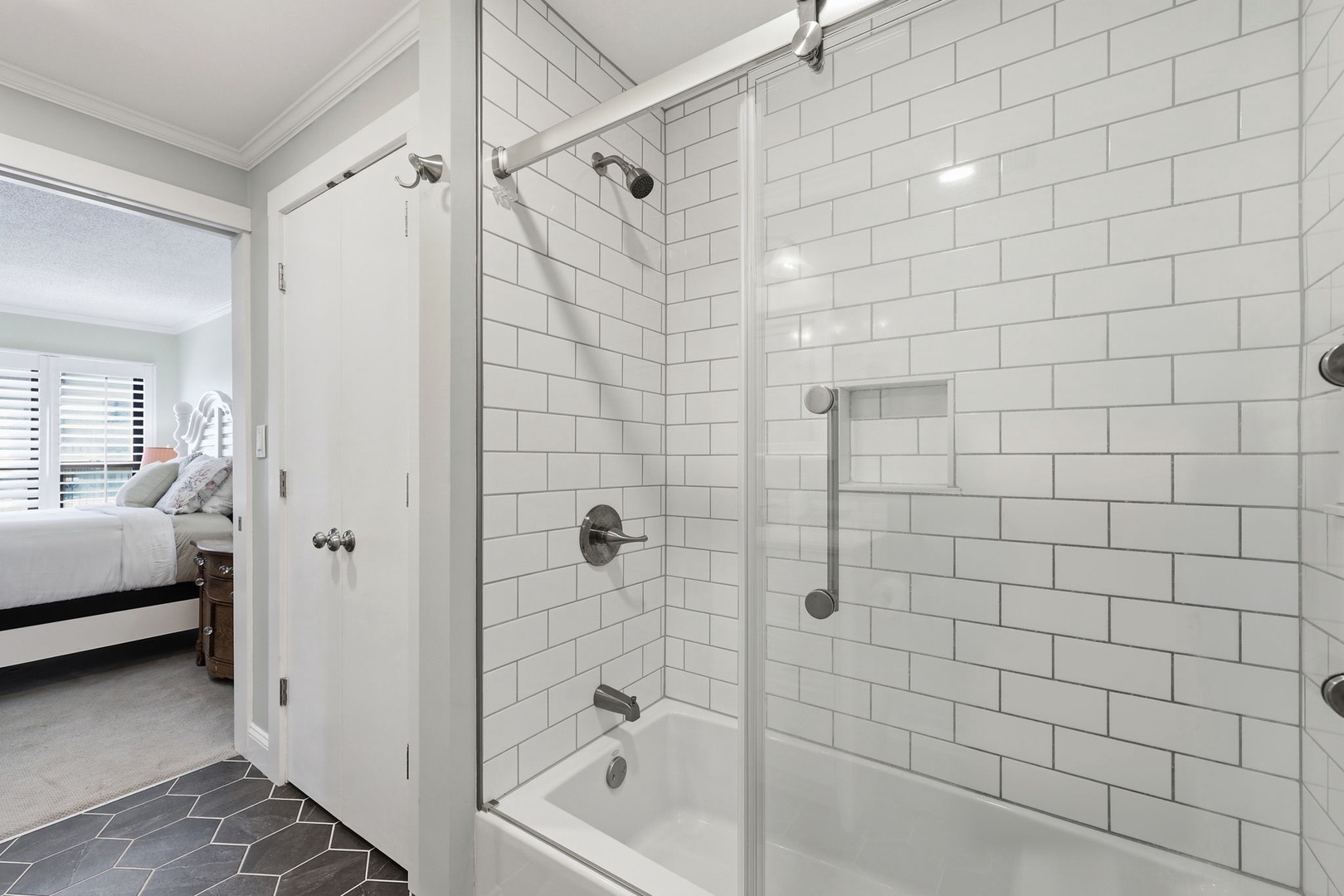 Step into your private ensuite, where crisp white subway tile and modern fixtures create a spa-like retreat. The spacious shower offers a refreshing escape after a day of exploring.