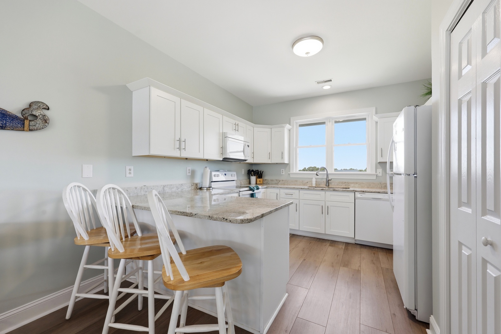 You'll love preparing meals in this bright, fully equipped kitchen with granite countertops, modern appliances, and a convenient breakfast bar for casual dining.