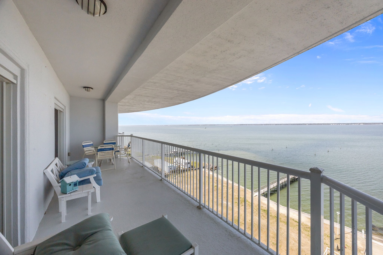 Spacious waterfront balcony with comfortable seating where you can enjoy morning coffee while watching the waves.