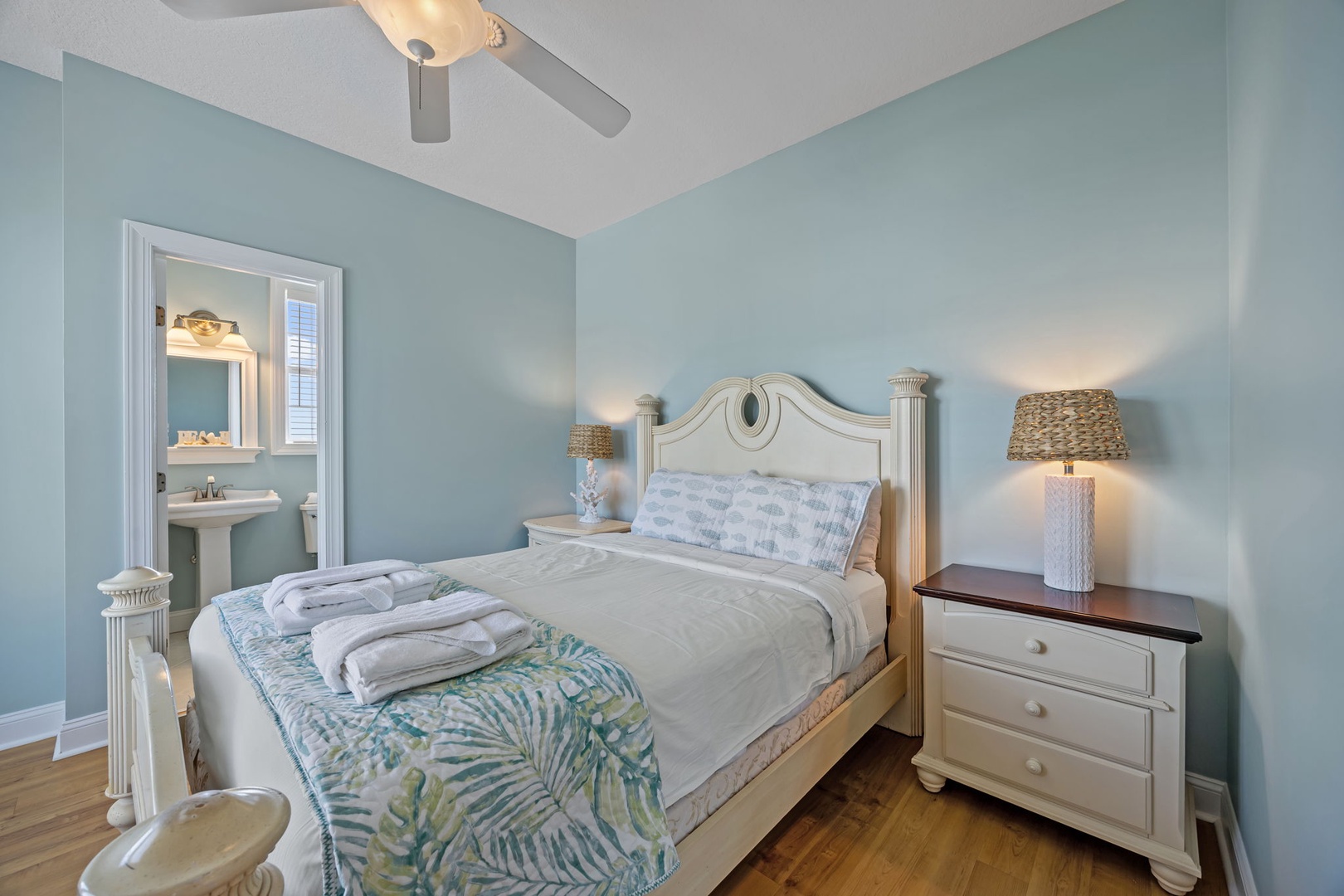 Drift off in your tranquil coastal bedroom, where soft blue walls and tropical touches create the perfect seaside sanctuary.