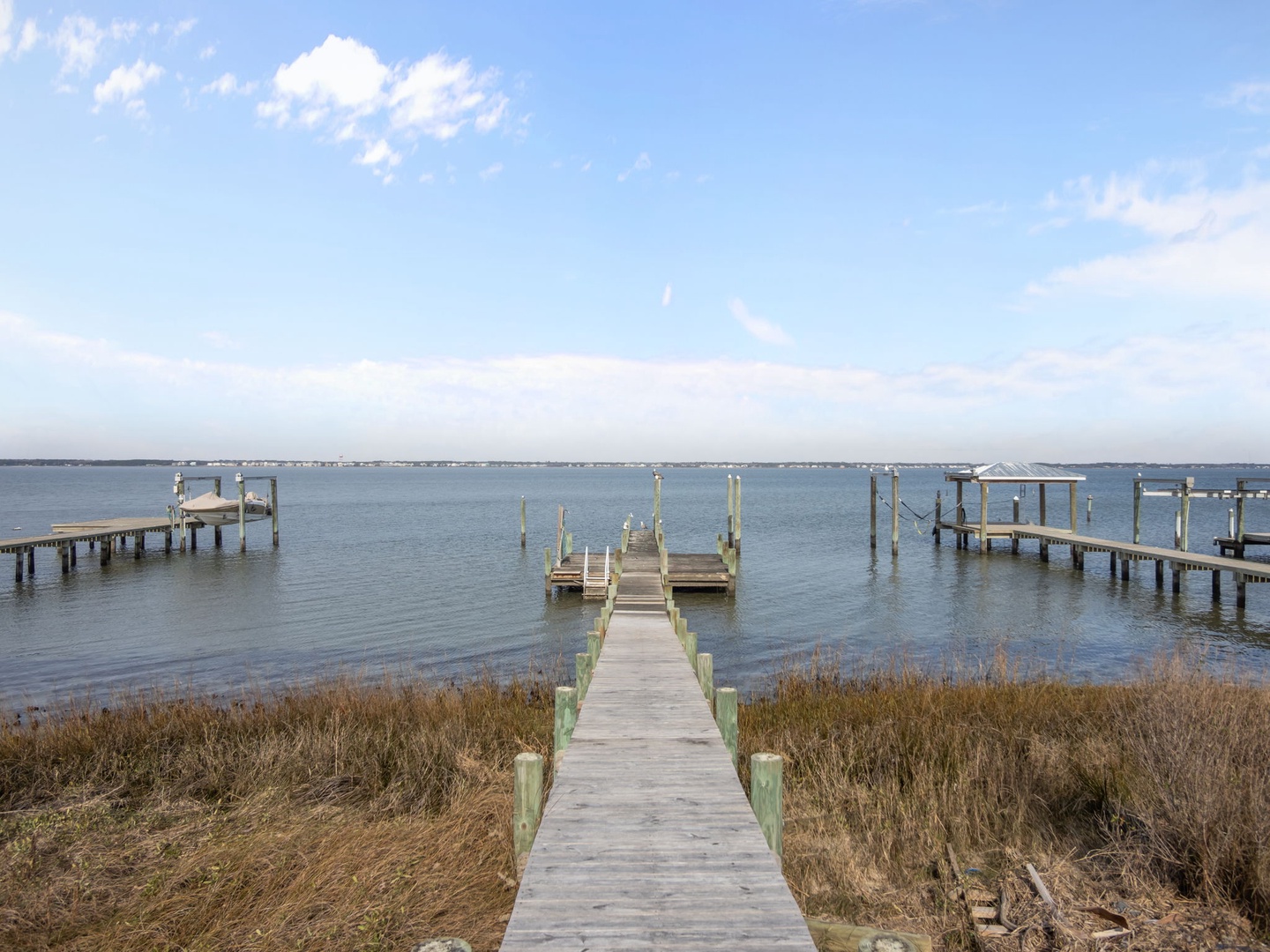 Waterfront location with private dock access to calm bay waters, surrounded by peaceful natural marshland.