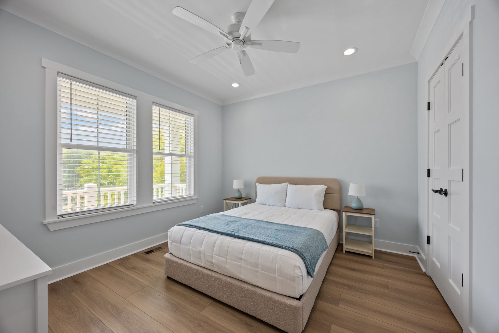 Your serene bedroom features soft blue walls and coastal decor, creating the perfect retreat after busy beach days.
