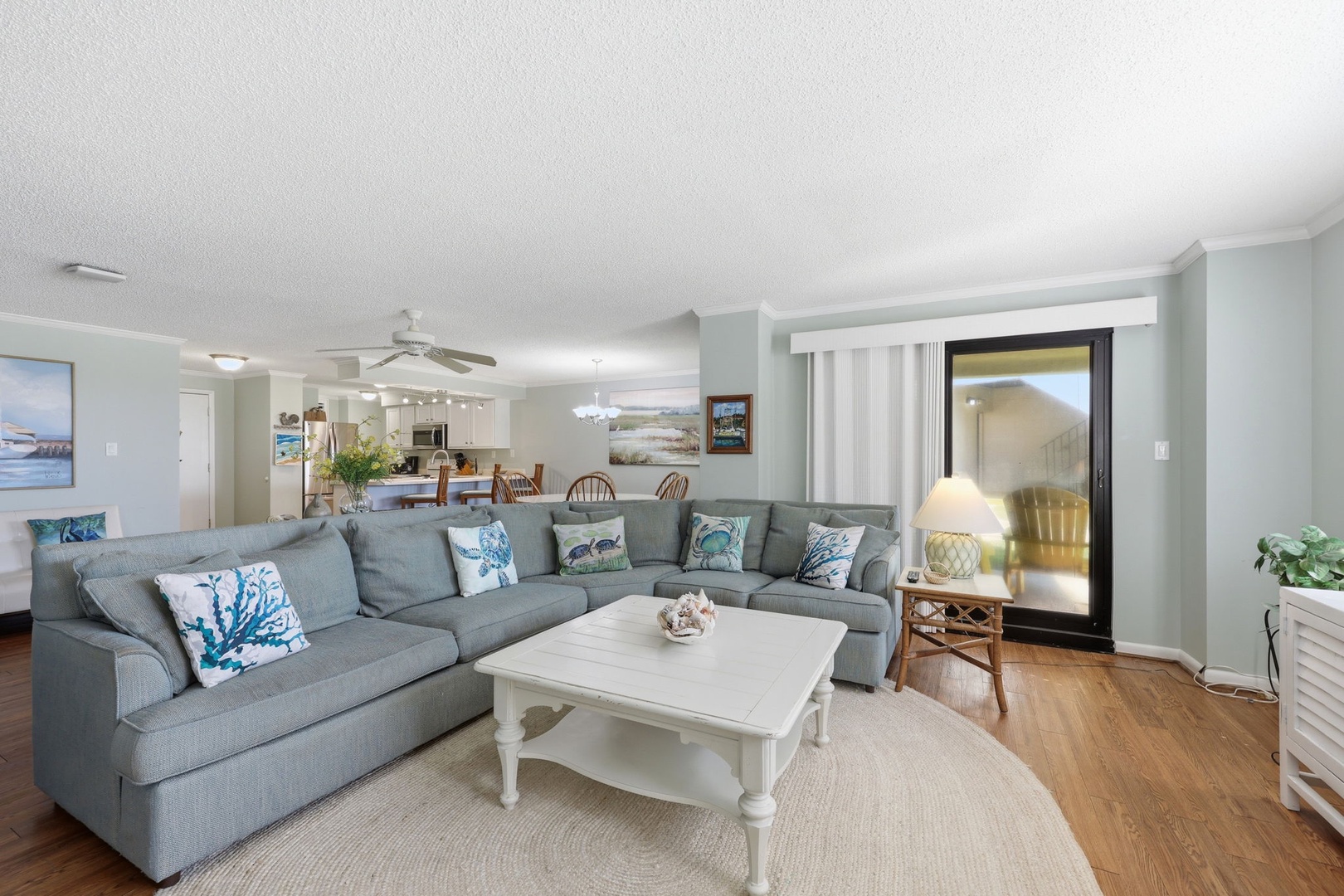 Relax in this bright, spacious living area where coastal charm meets comfort. The plush sectional and open layout invite you to unwind after a day of exploring nearby beaches.