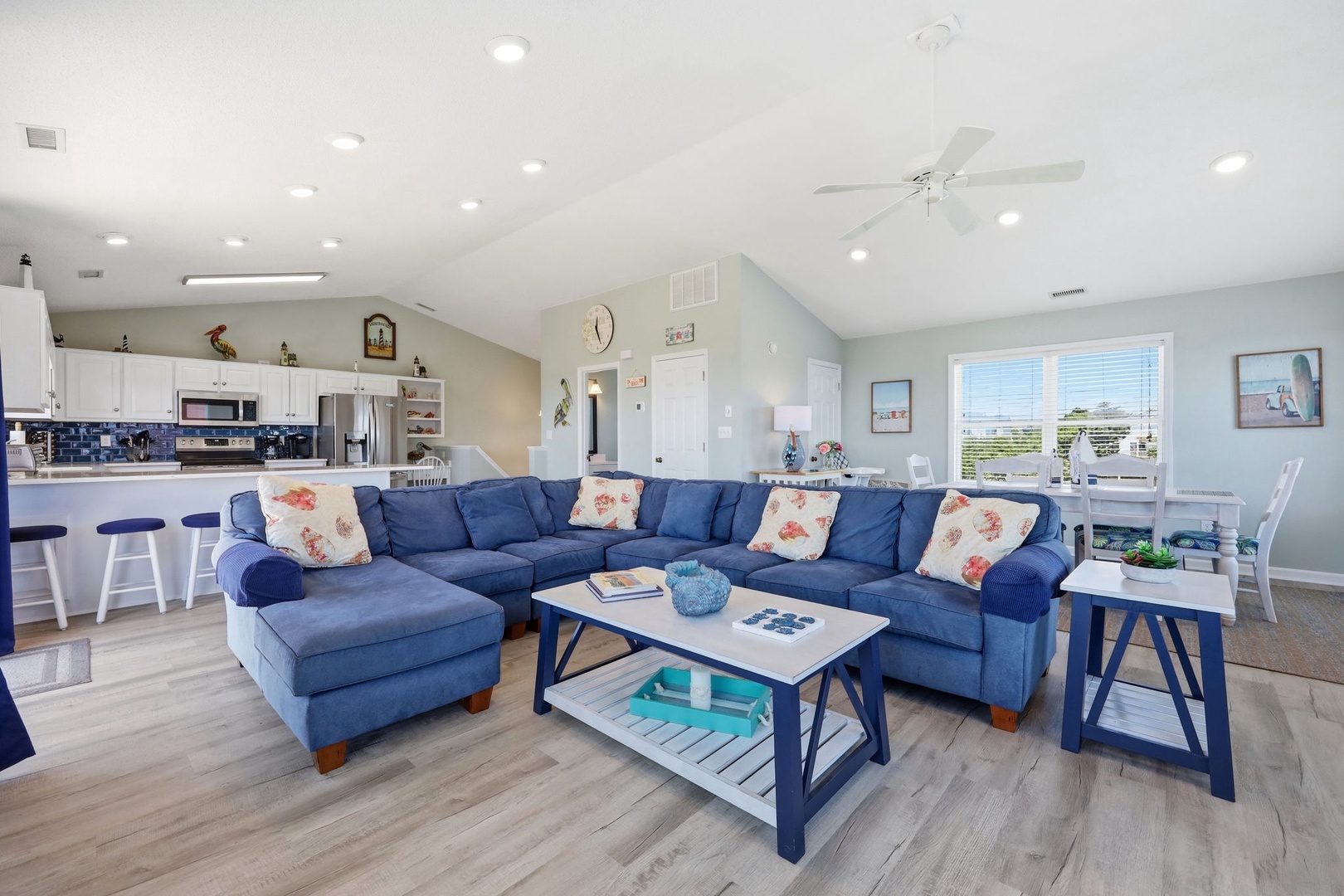 Sink into the plush blue sectional with a book, or unwind at the breakfast bar where coffee and conversation flow. Bright windows and coastal touches make you feel at home instantly.
