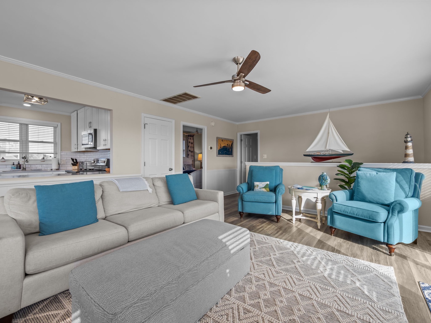 Relax in your coastal-themed living room with plush seating, nautical touches, and an open layout connecting to your kitchen.
