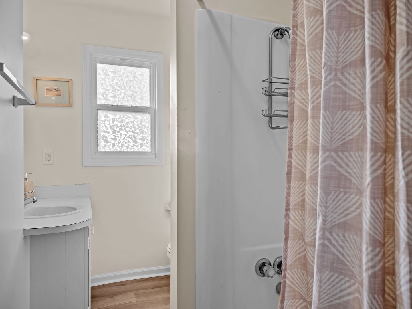 Step into your bright bathroom featuring a shower/tub combo and natural light streaming through the window.