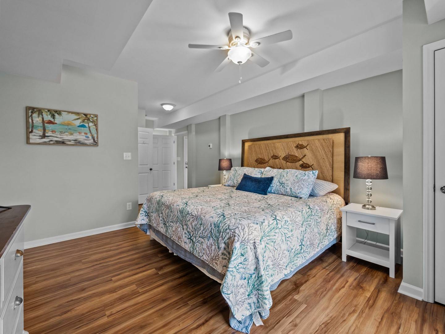 Unwind in your coastal-inspired bedroom with charming exposed beams and ocean-themed décor creating a serene retreat.