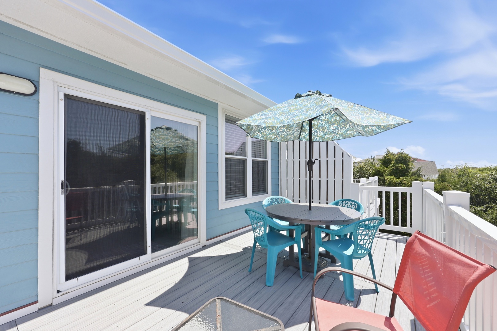 Your private deck offers a perfect spot to enjoy morning coffee or afternoon refreshments outdoors, complete with shaded dining for four and comfortable seating under coastal skies.