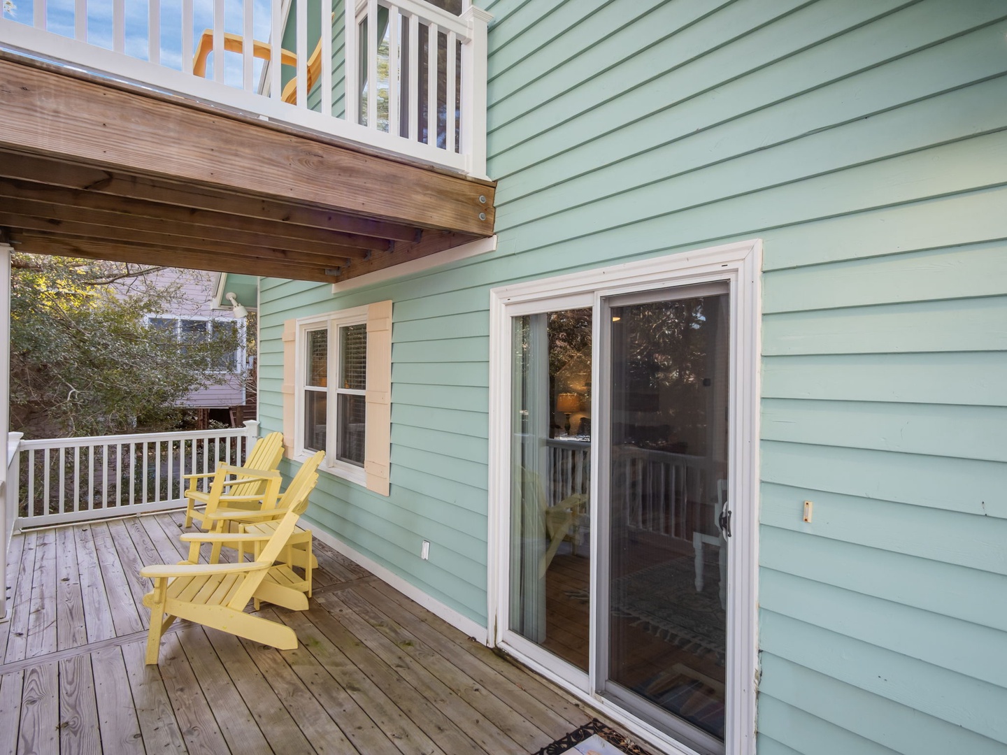 Step out onto your private deck with cheerful yellow Adirondack chairs, perfect for morning coffee or evening relaxation under the covered porch.
