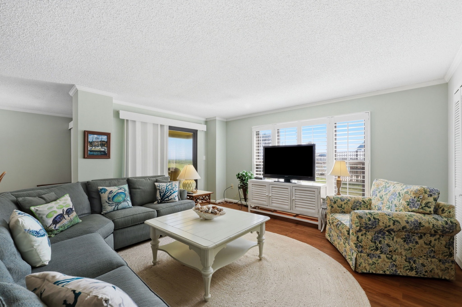 Sink into plush seating and unwind as natural light pours through plantation shutters. Your coastal getaway features cozy furnishings, a large TV for movie nights, and serene views.