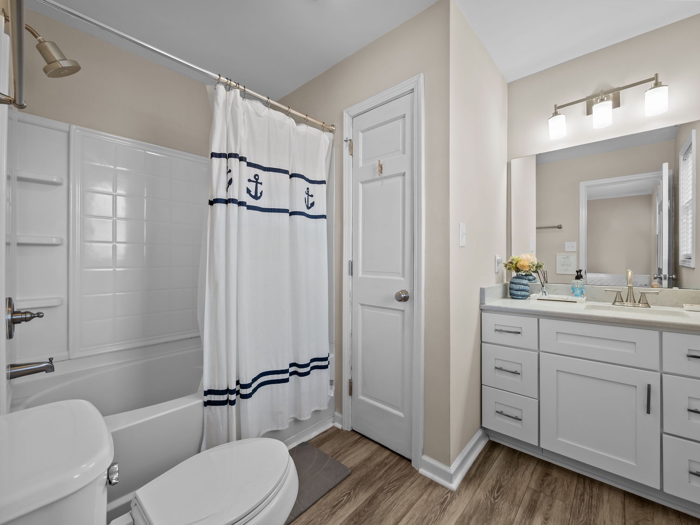 Refresh in your private bathroom featuring a spacious shower-tub combo and crisp nautical touches that bring coastal charm to your daily routine.
