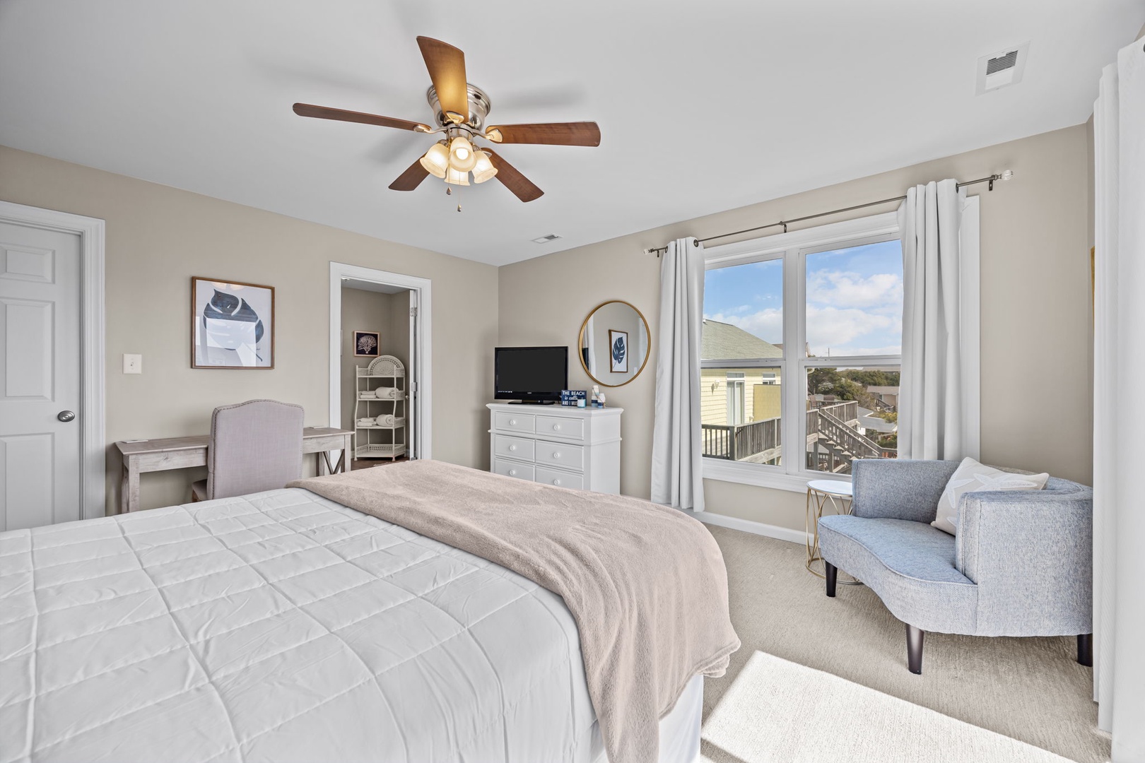 Relax in your serene bedroom with ocean views and coastal charm, featuring plush bedding and a cozy reading nook.
