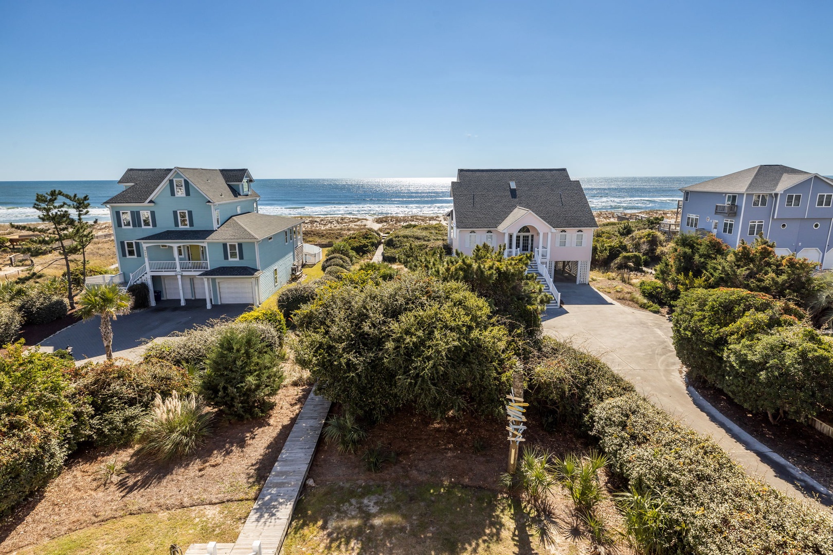 Coastal rental homes nestled among native vegetation with direct beach access and ocean views.