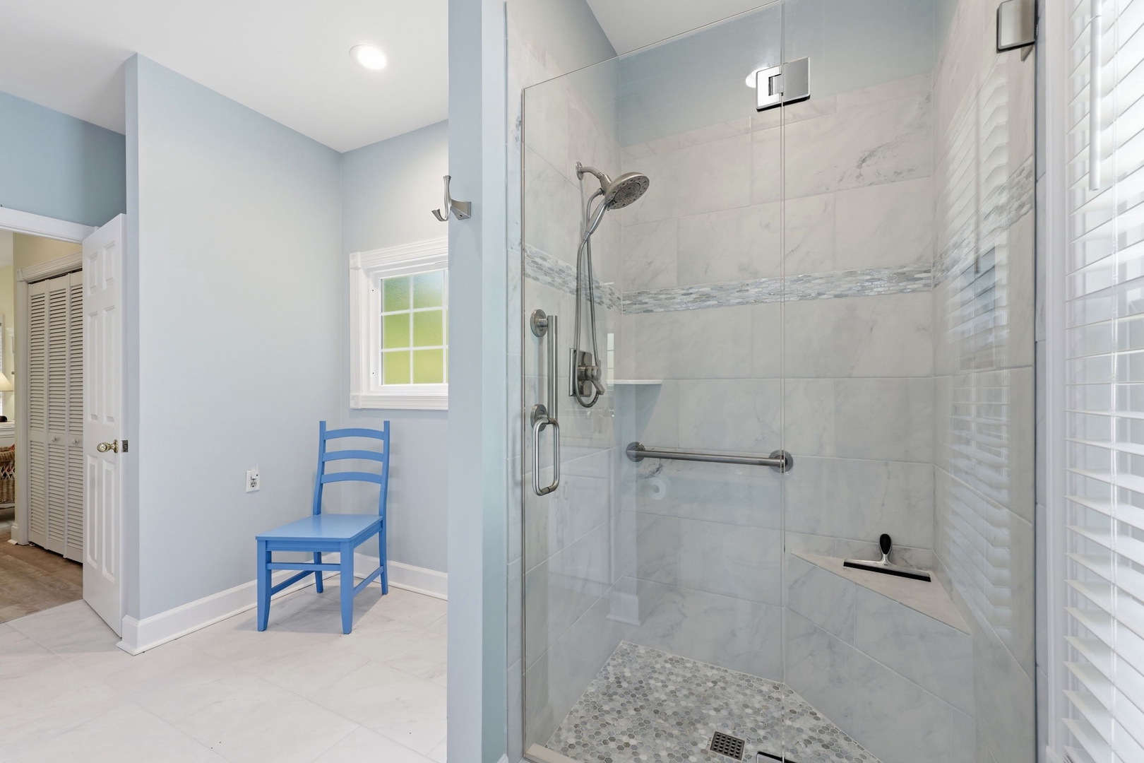 Refresh in your spacious walk-in shower with marble tile and rainfall showerhead—designed with accessibility features and coastal-inspired finishes for your comfort.