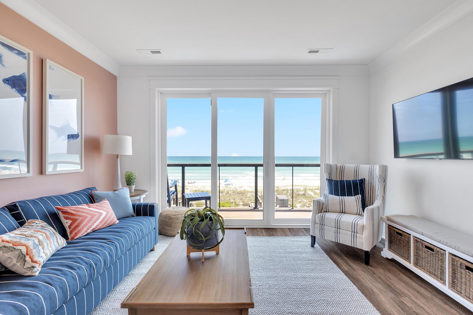 Sink into comfort in your bright living room, where the coastal palette and plush seating invite you to unwind. Glass doors open to your balcony, bringing the beach just steps away.