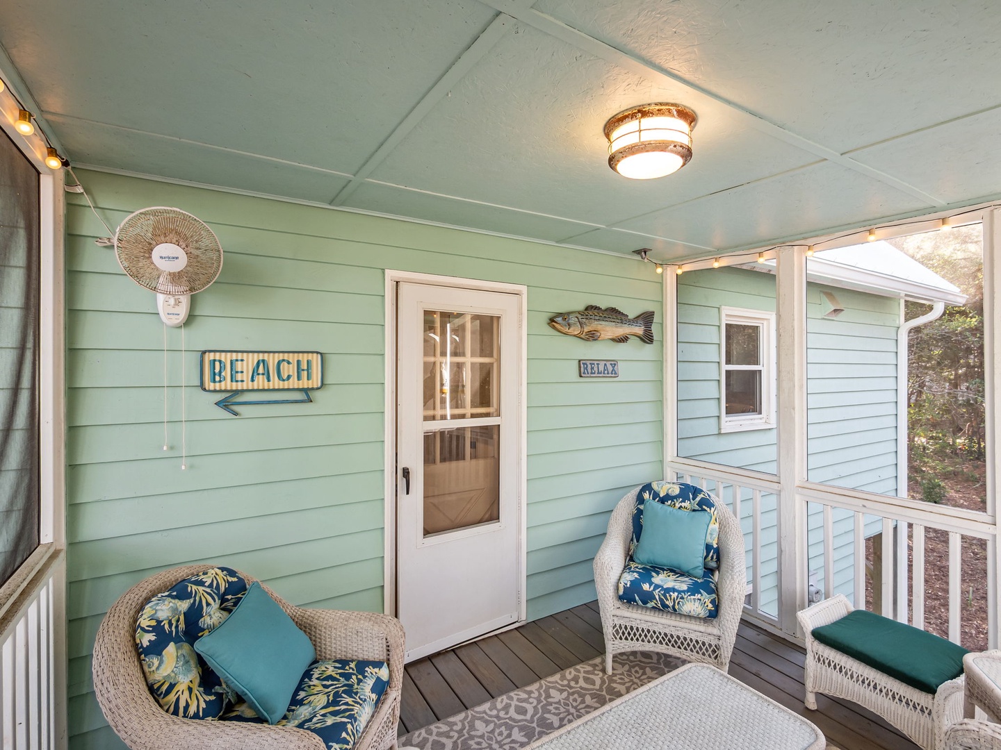 Unwind on your private covered porch with comfortable wicker seating and coastal charm—perfect for morning coffee or evening relaxation.