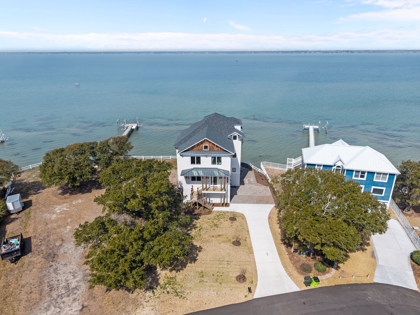 Waterfront property with private beach access and docks, surrounded by mature trees on the bay.