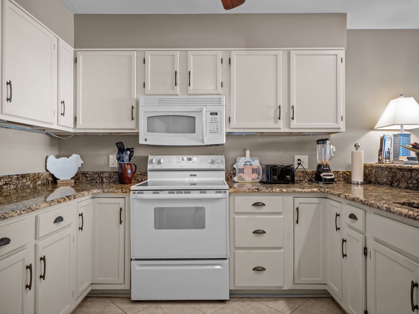 Your fully equipped kitchen awaits with granite counters, white appliances, and everything needed to create delicious meals during your stay.