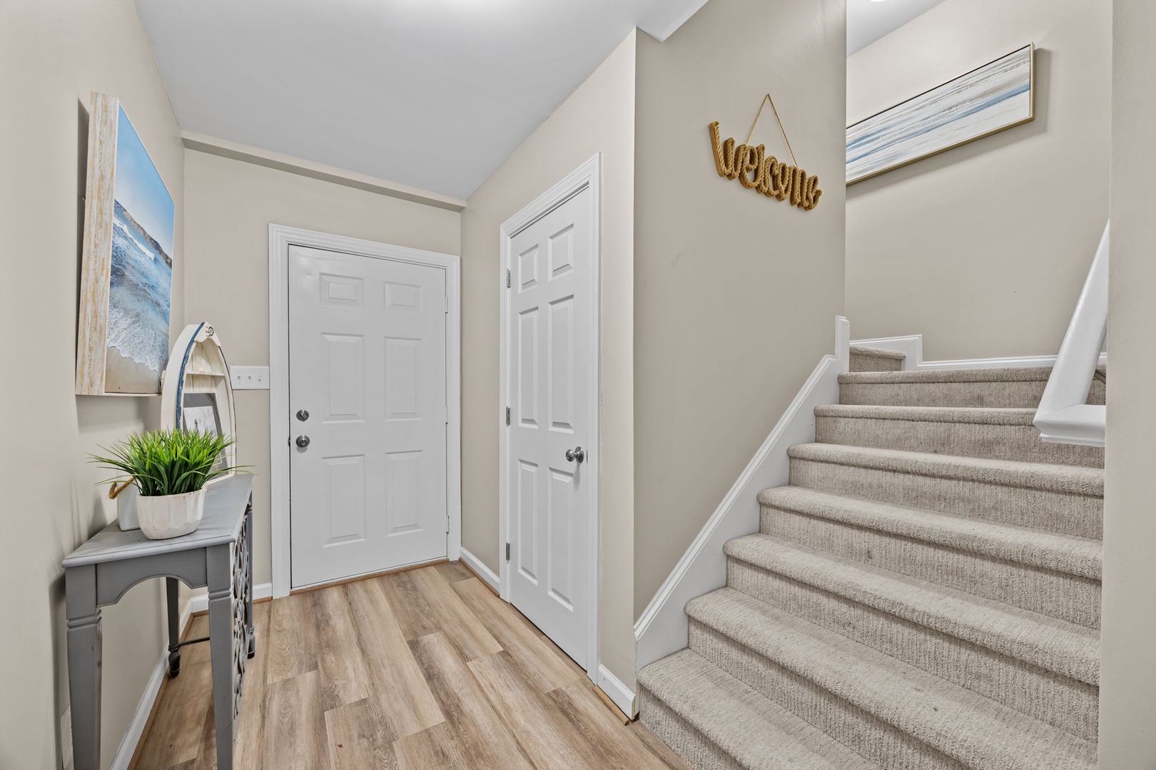 Step into your welcoming entryway, where coastal artwork and warm touches create an instantly relaxing atmosphere.