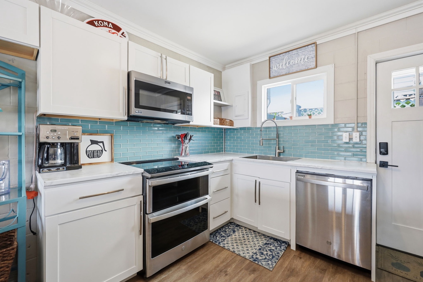 Your bright, fully-equipped kitchen features modern appliances, gleaming countertops, and a cheerful turquoise backsplash to inspire your morning coffee routine.