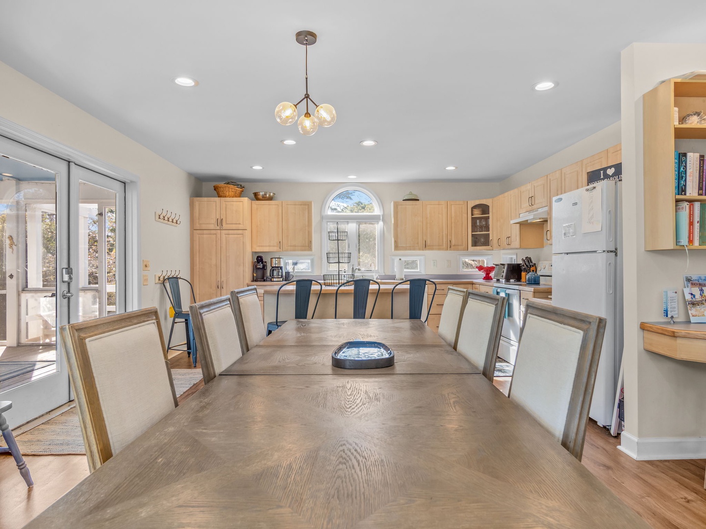 Gather around this spacious dining table where your group can share meals and create memories in this bright, open kitchen.