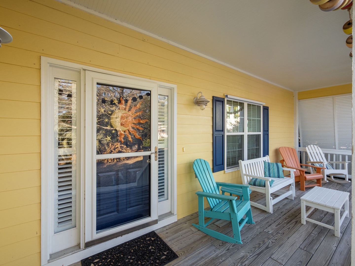 Your bright yellow porch welcomes you with colorful Adirondack chairs perfect for morning coffee and sunset conversations.