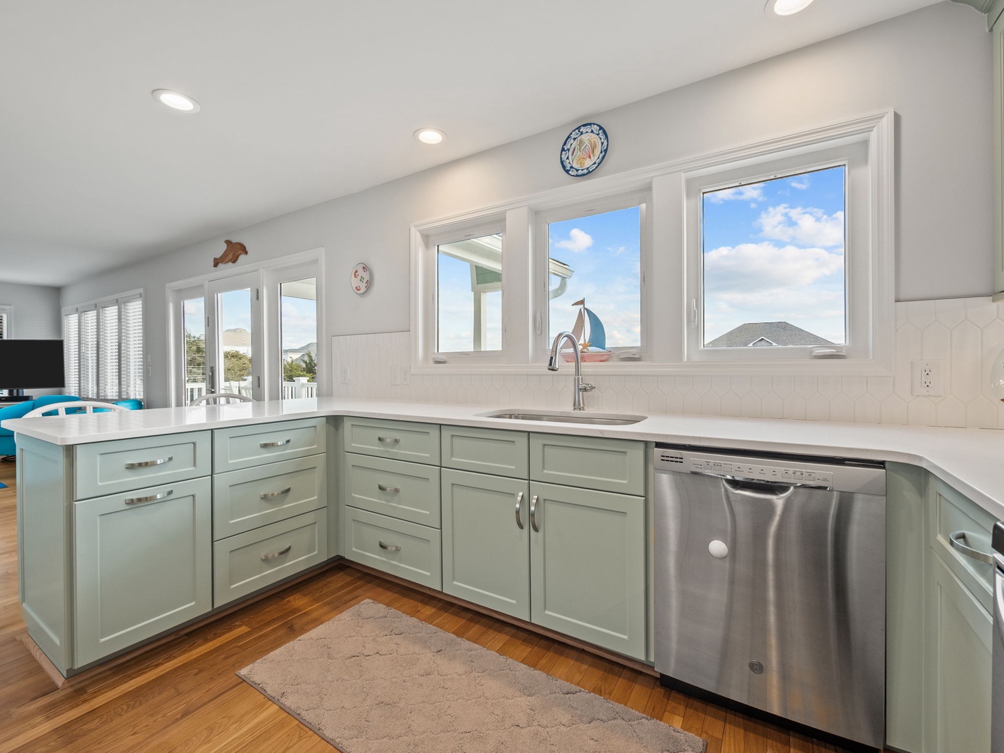 Your bright kitchen features sea-glass cabinets, quartz counters, and panoramic windows flooding the space with natural light.