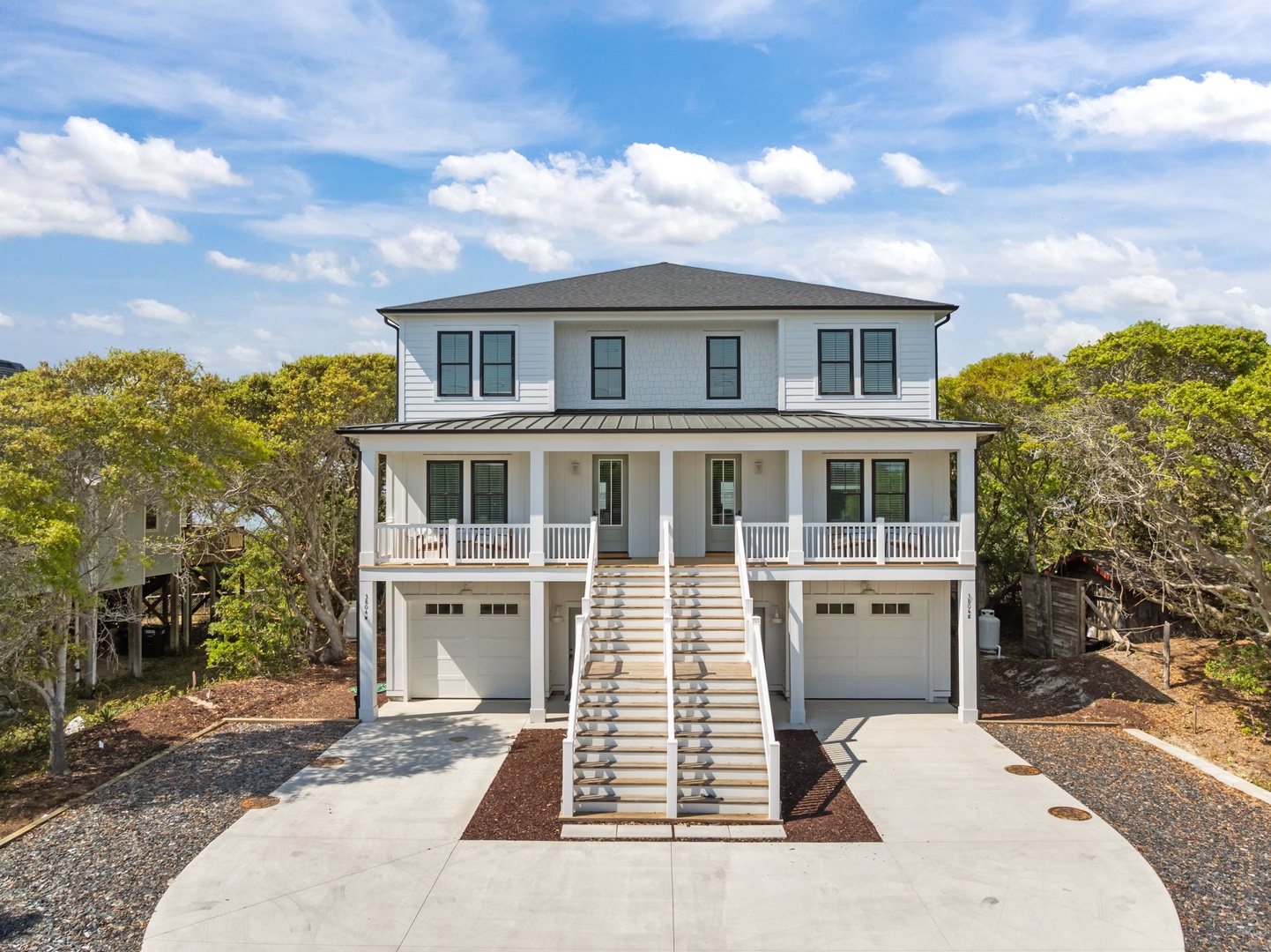Beautiful coastal home surrounded by lush greenery offers modern comfort with classic charm and convenient parking for your beach getaway.
