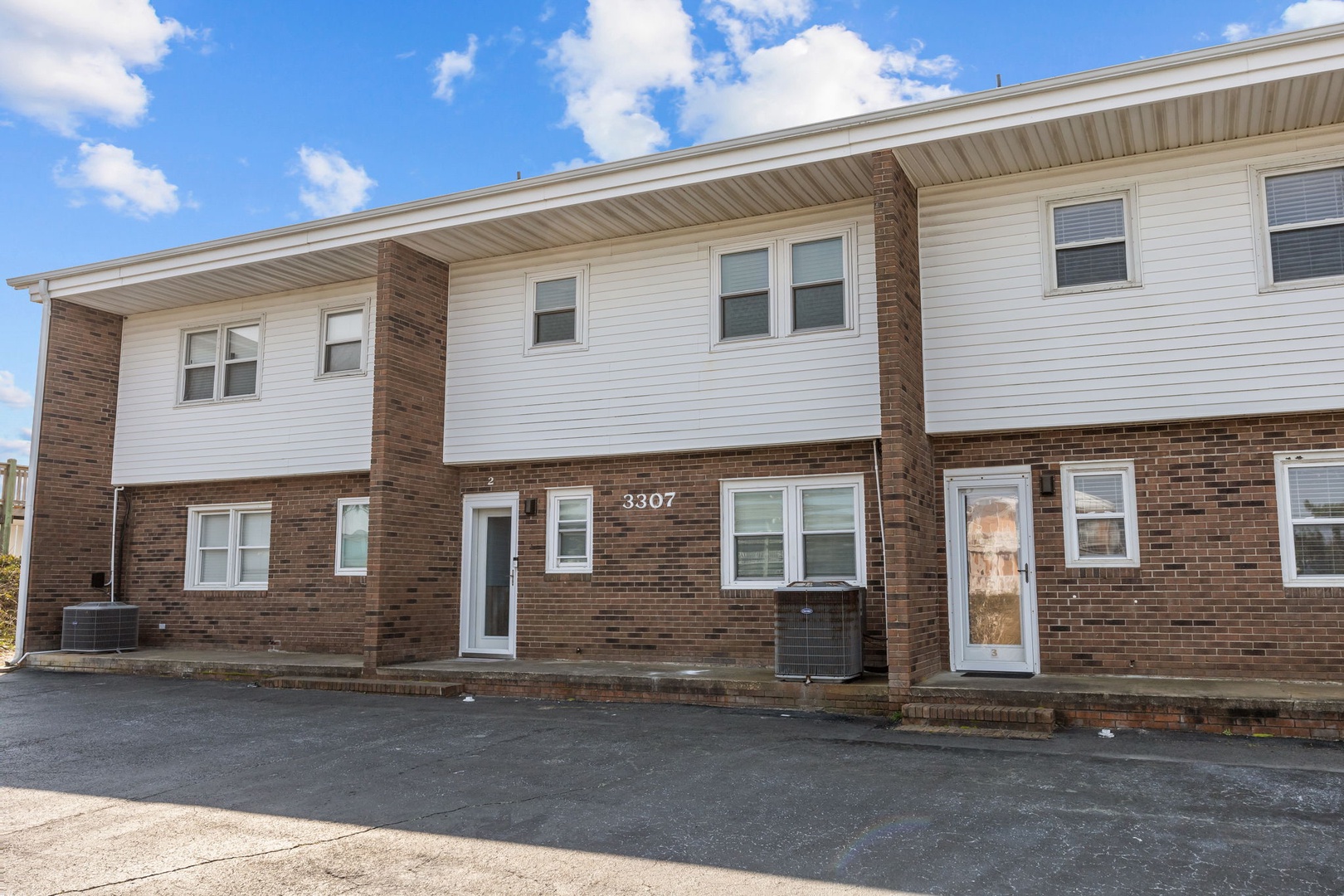 Spacious brick and vinyl siding building with multiple units offering comfortable accommodations in a convenient location.