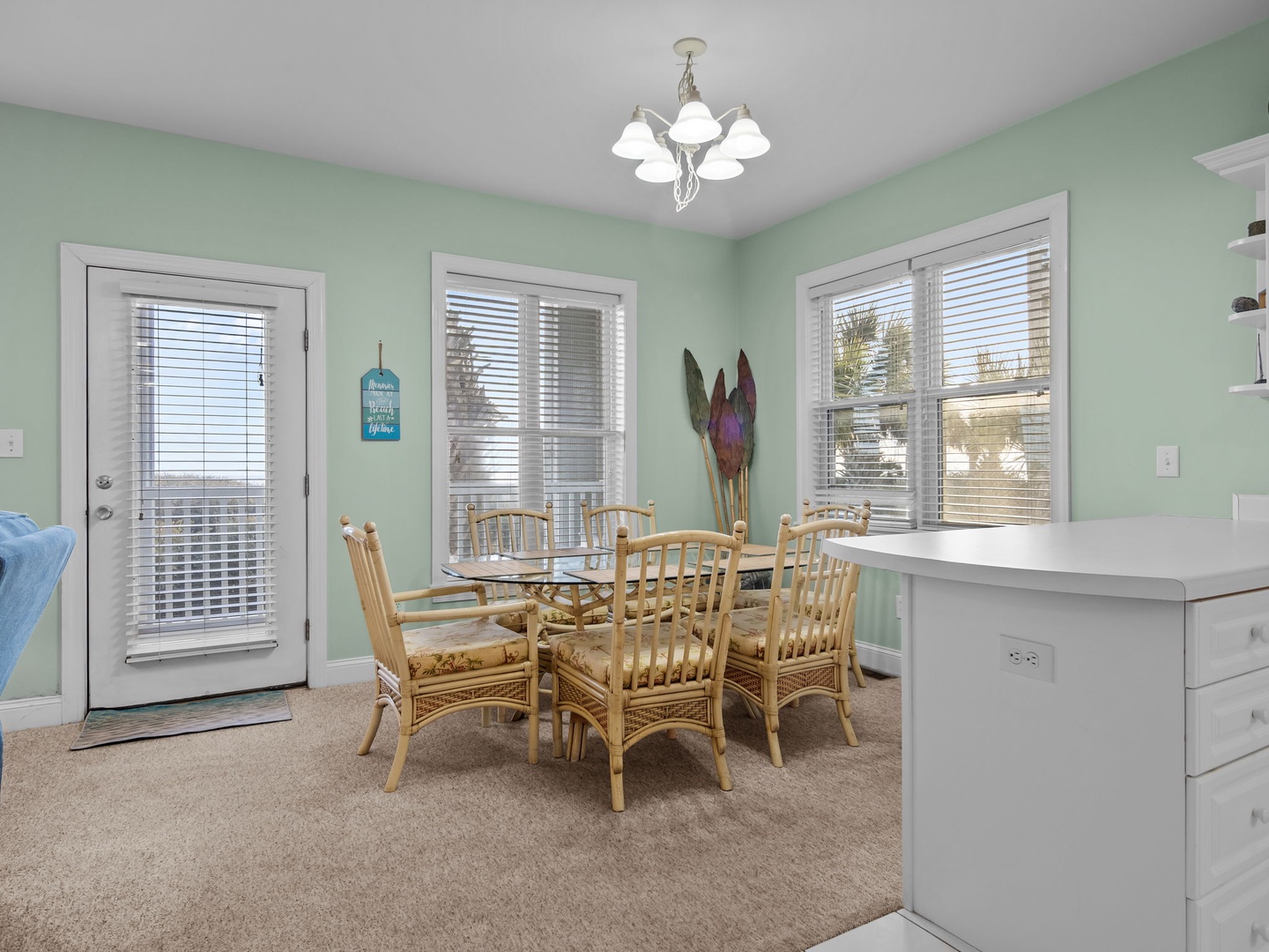 Gather around your coastal-style dining table in this bright, inviting space with soothing mint walls and plenty of natural light.