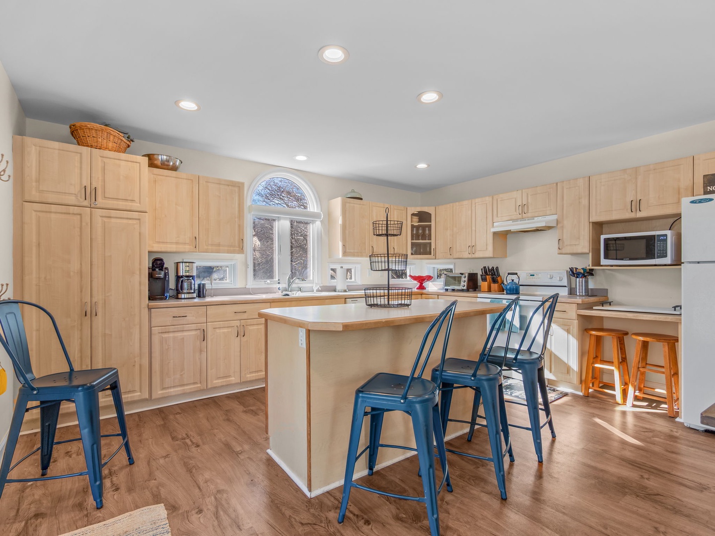 Your spacious kitchen invites culinary adventures with warm wood cabinetry, modern appliances, and a welcoming island perfect for morning coffee or evening gatherings.