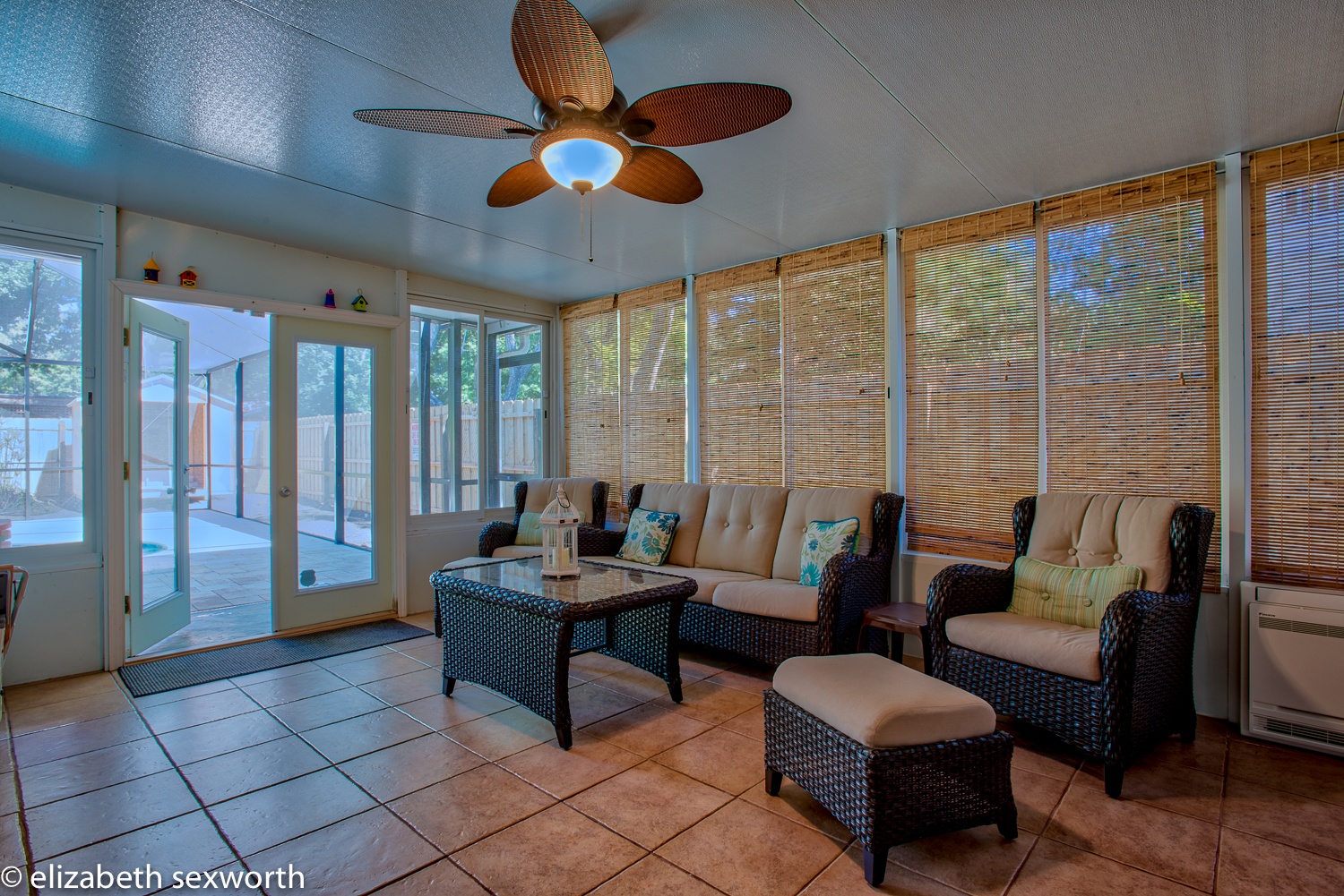 Florida room has all-weather wicker furniture and a mini-split