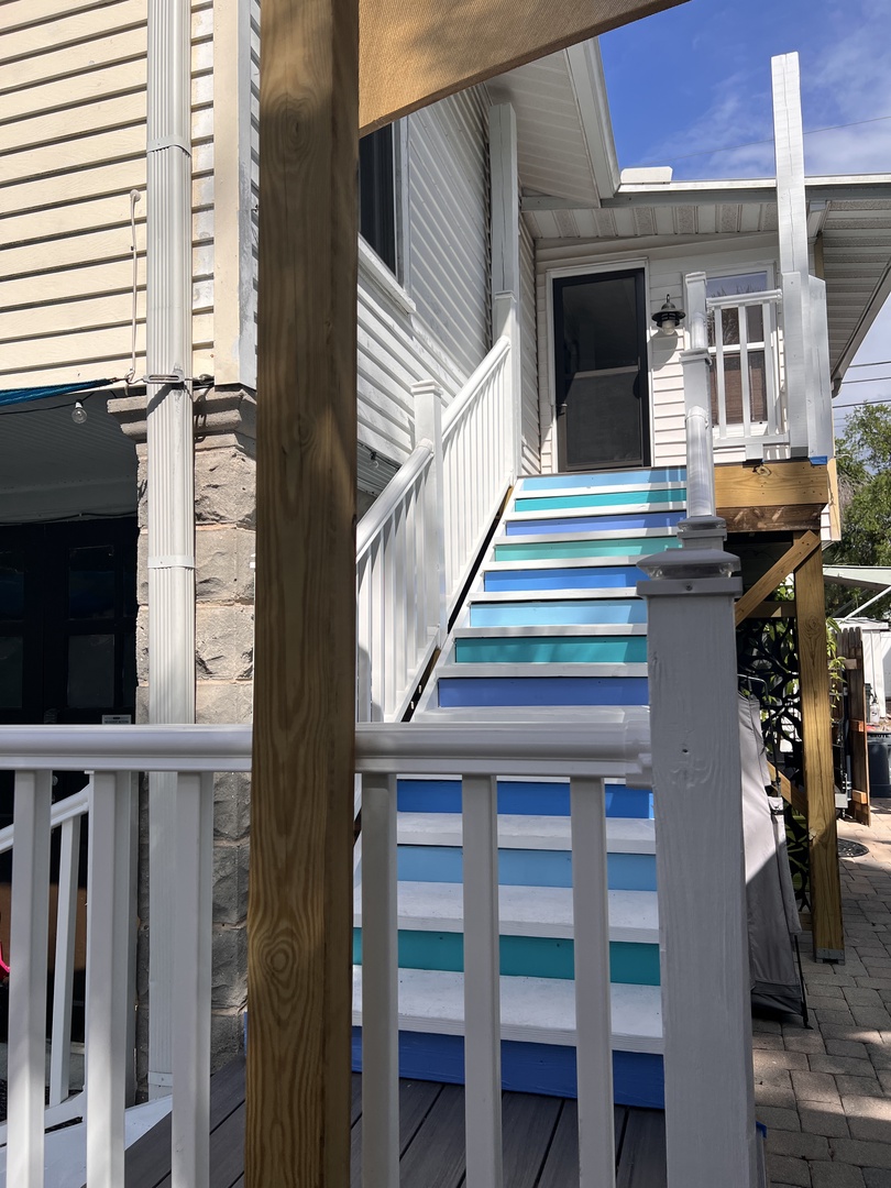 Your private deck offers the perfect spot to unwind with colorful beach-style railings and comfortable outdoor seating.