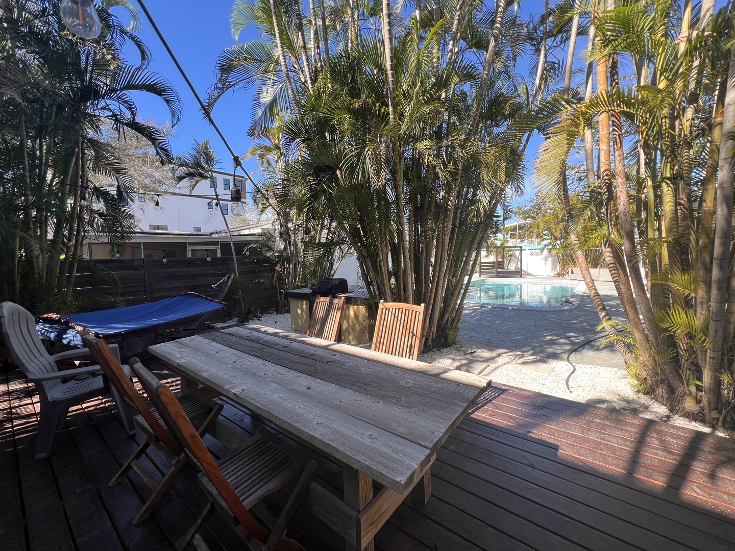 Unwind at your tropical outdoor dining space where palm trees sway overhead and the sparkling pool beckons just steps away.