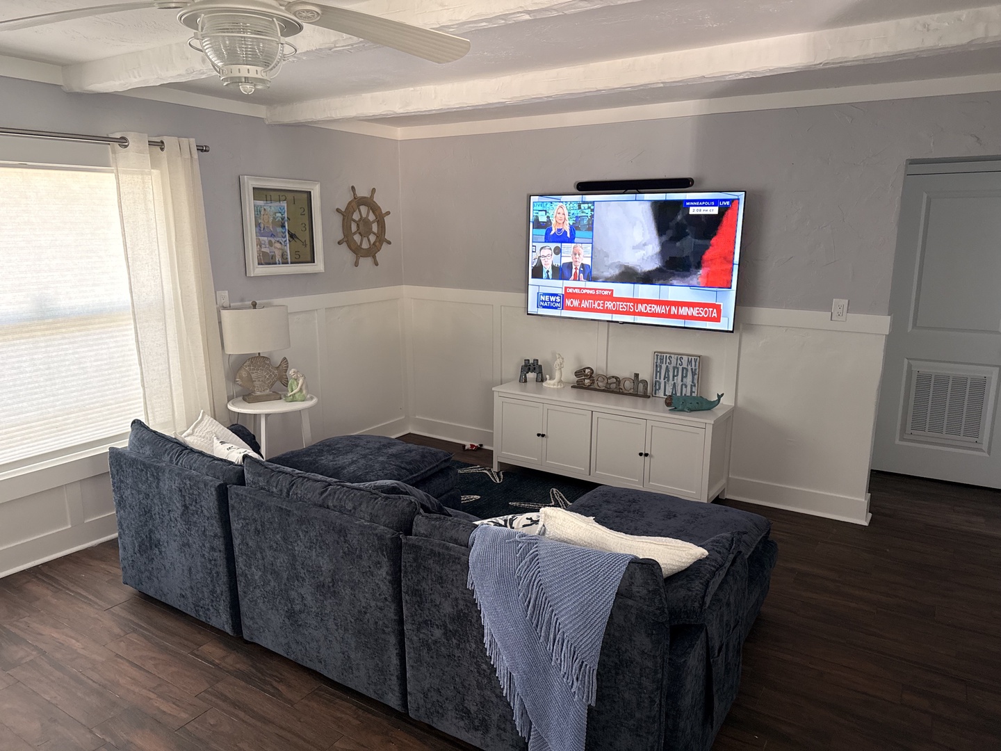 Sink into this plush sectional sofa and enjoy your favorite shows on the large flat-screen TV in this bright, coastal-themed living space.