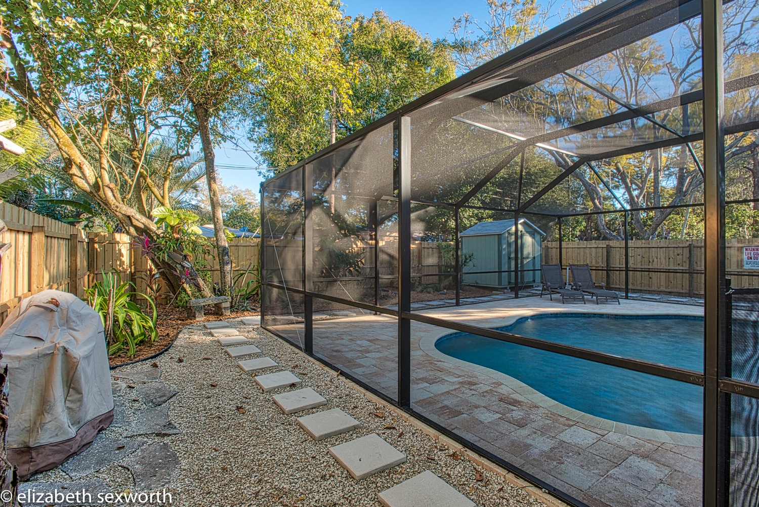 Outside yard by the grill on the west side of the pool cage