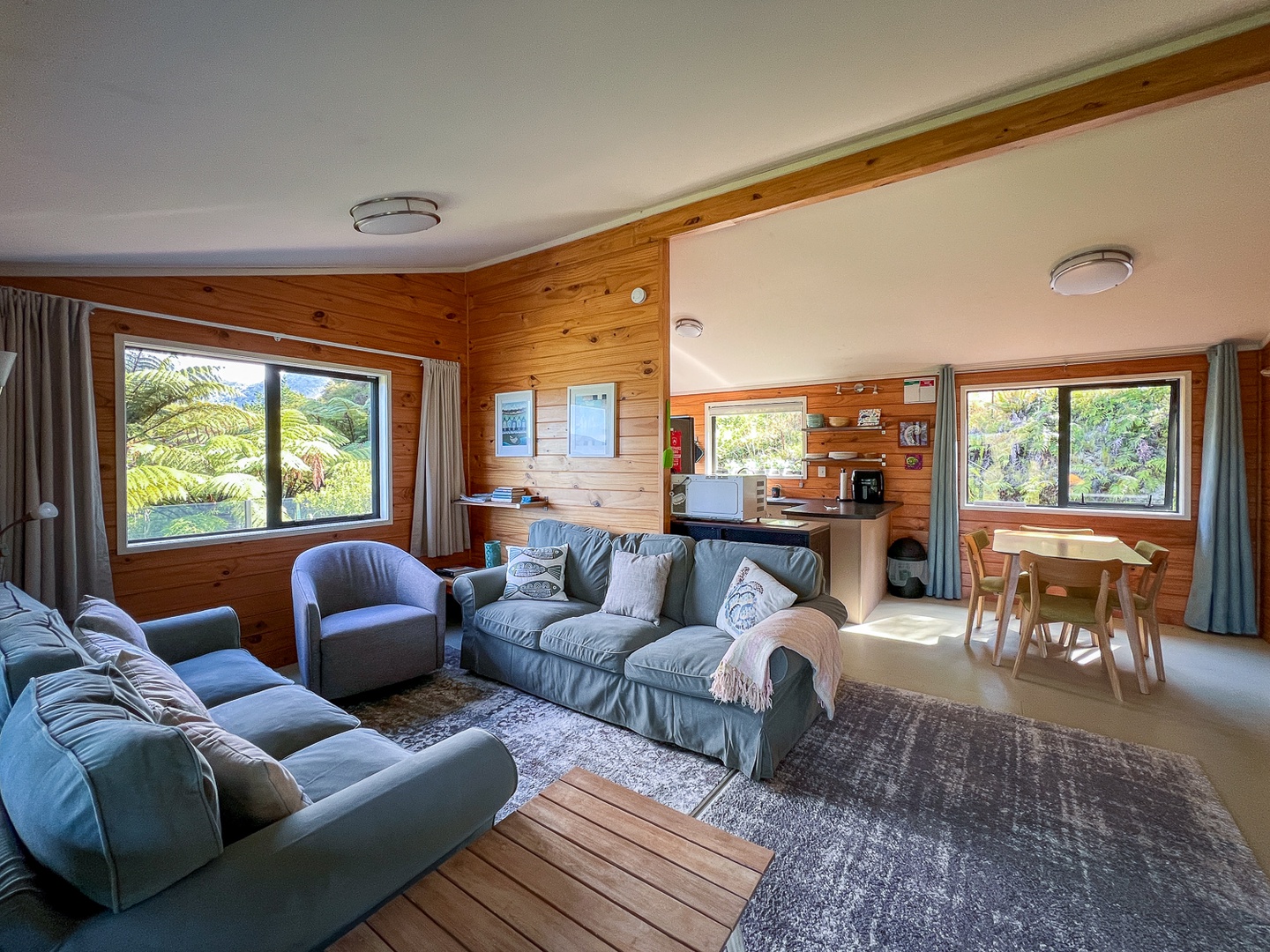 Sink into the comfy sofas and soak up tropical views through panoramic windows in this bright, open-plan living space.