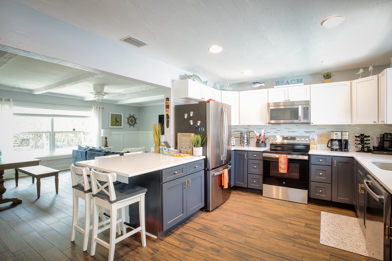 Your spacious kitchen features modern appliances and a breakfast bar where you can prepare meals while enjoying ocean-themed coastal charm.