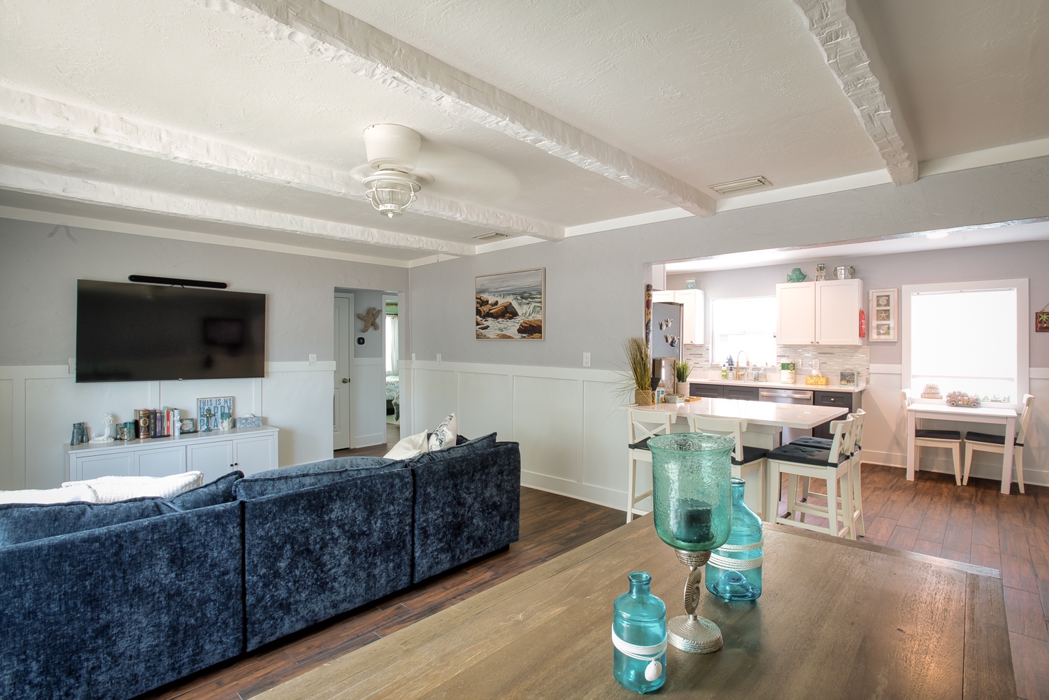 Relax in this elegant open-plan living space where coastal charm meets modern comfort. Your home away from home features exposed beams and thoughtful décor.