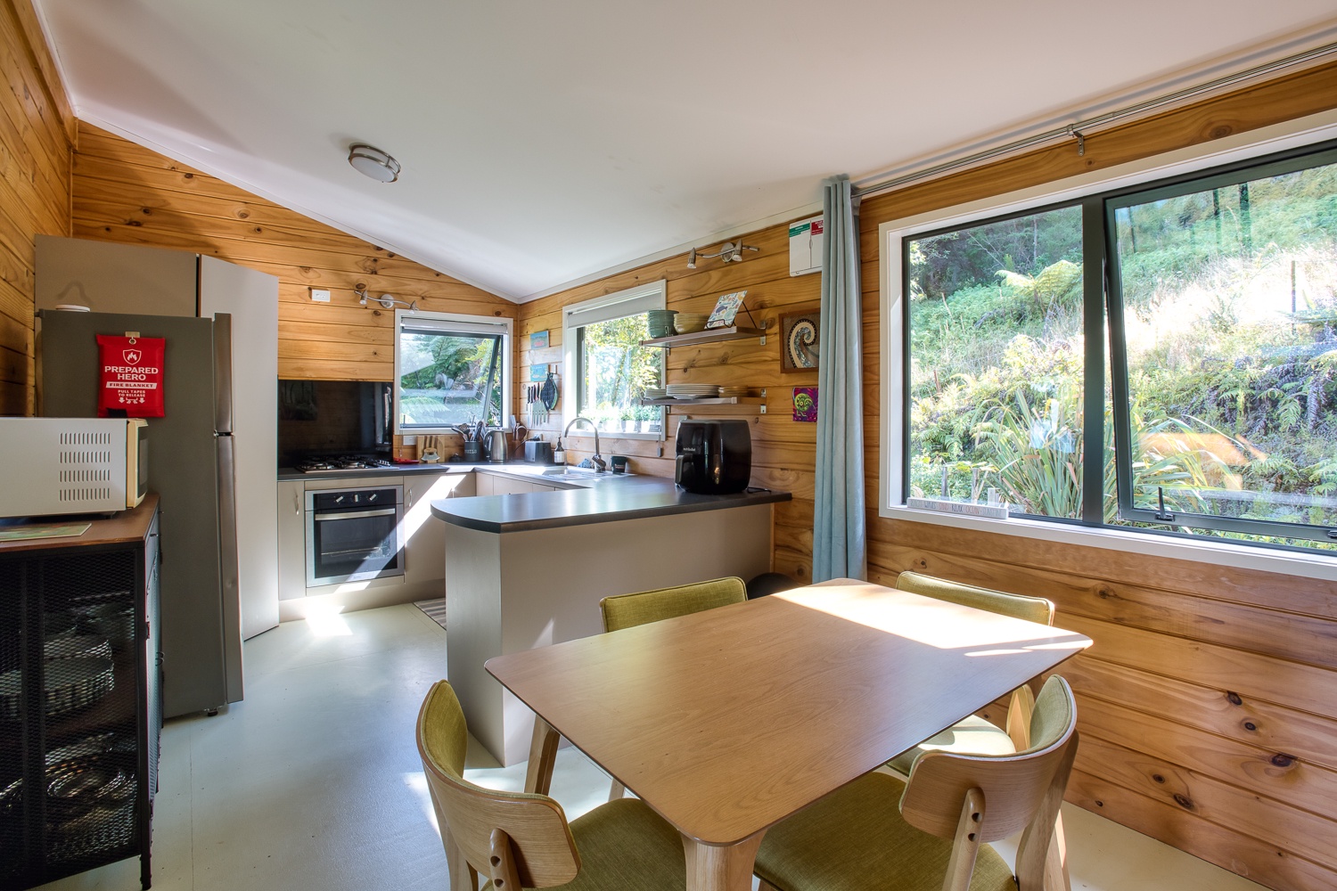 Prepare meals in your stylish kitchen while enjoying stunning garden views through expansive windows that flood the space with natural light.