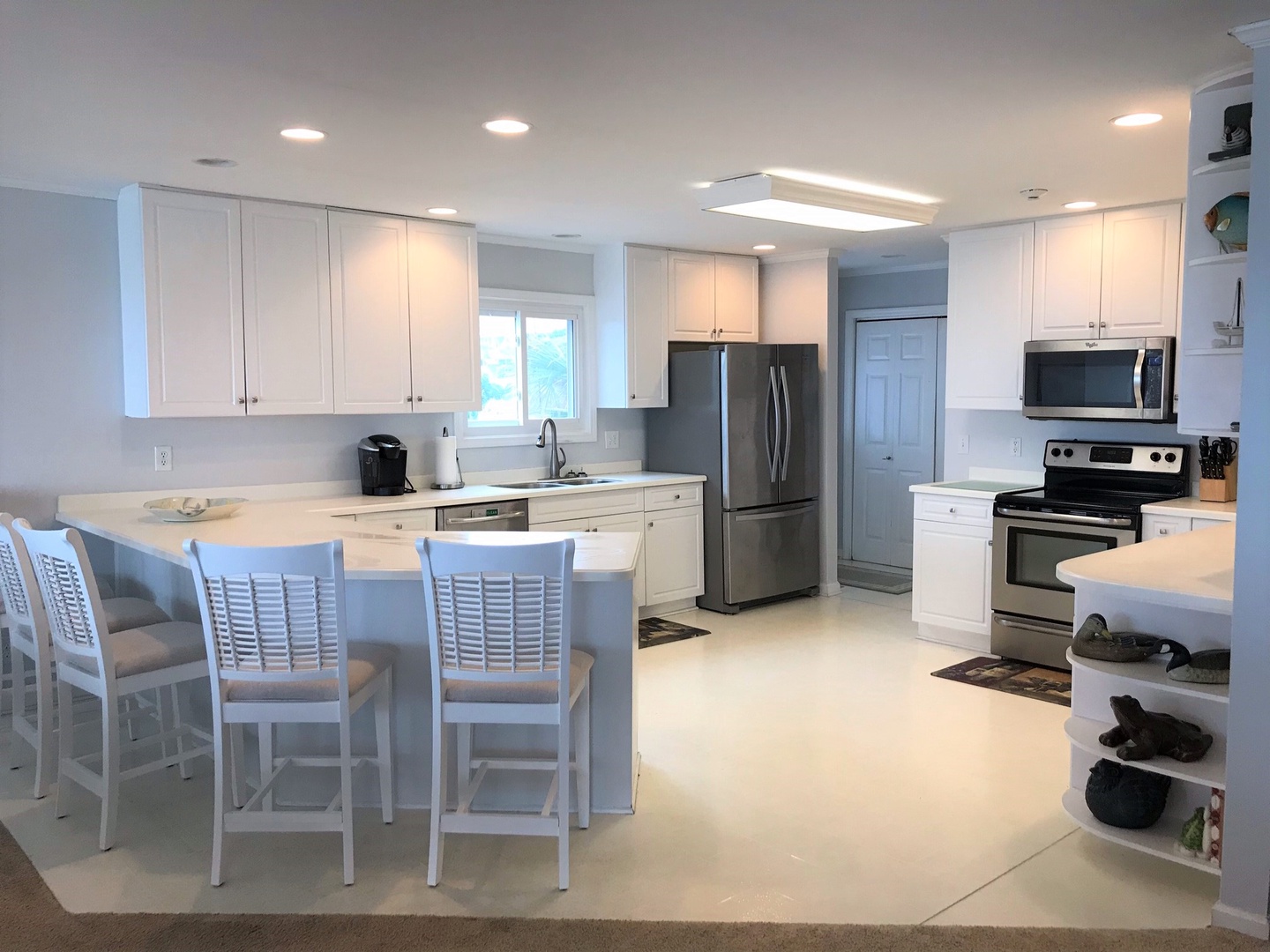 You'll love cooking in this bright, modern kitchen with crisp white cabinets, stainless steel appliances, and a breakfast bar perfect for morning coffee.